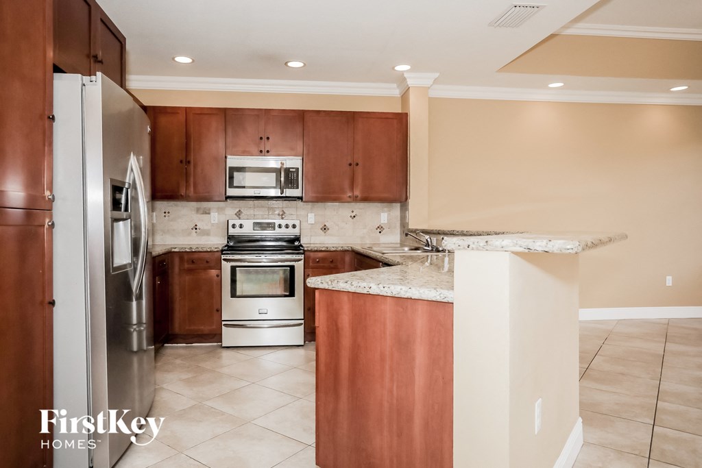 a kitchen with wooden cabinets and stainless steel appliances