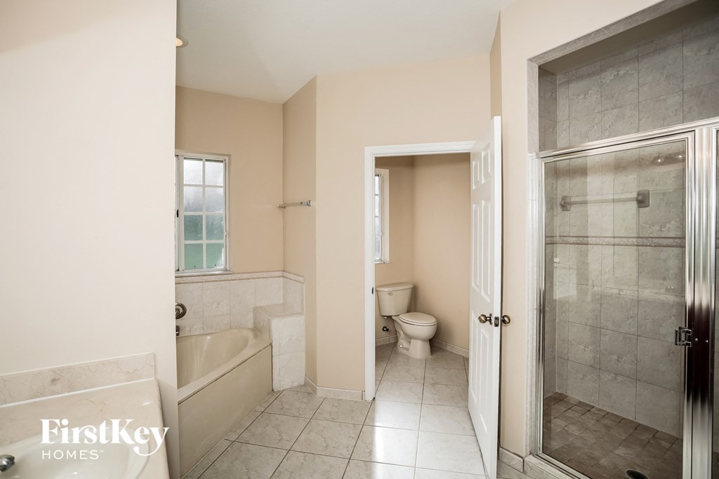 a bathroom with a toilet and a shower and a tub
