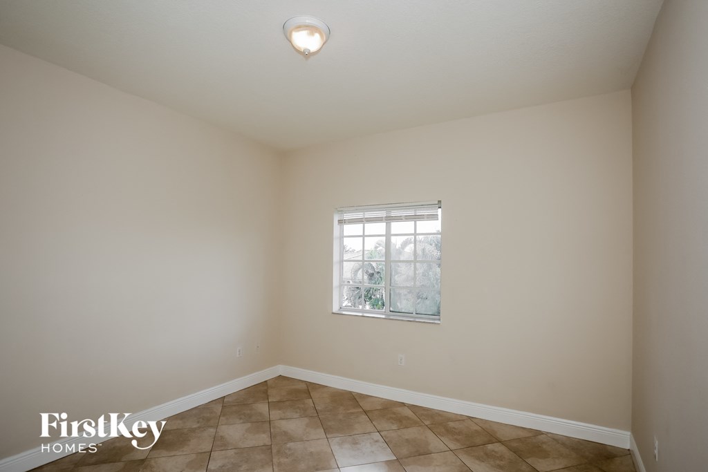 the living room of a home with beige walls and a window