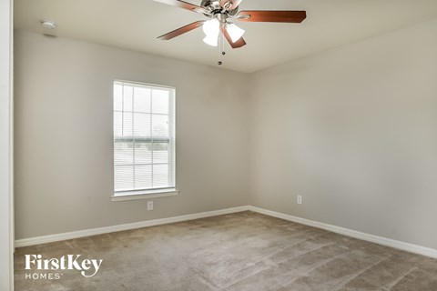 a bedroom with a ceiling fan and a window