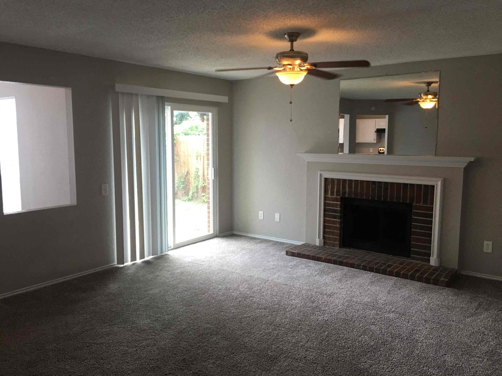 a living room with a fireplace and a ceiling fan