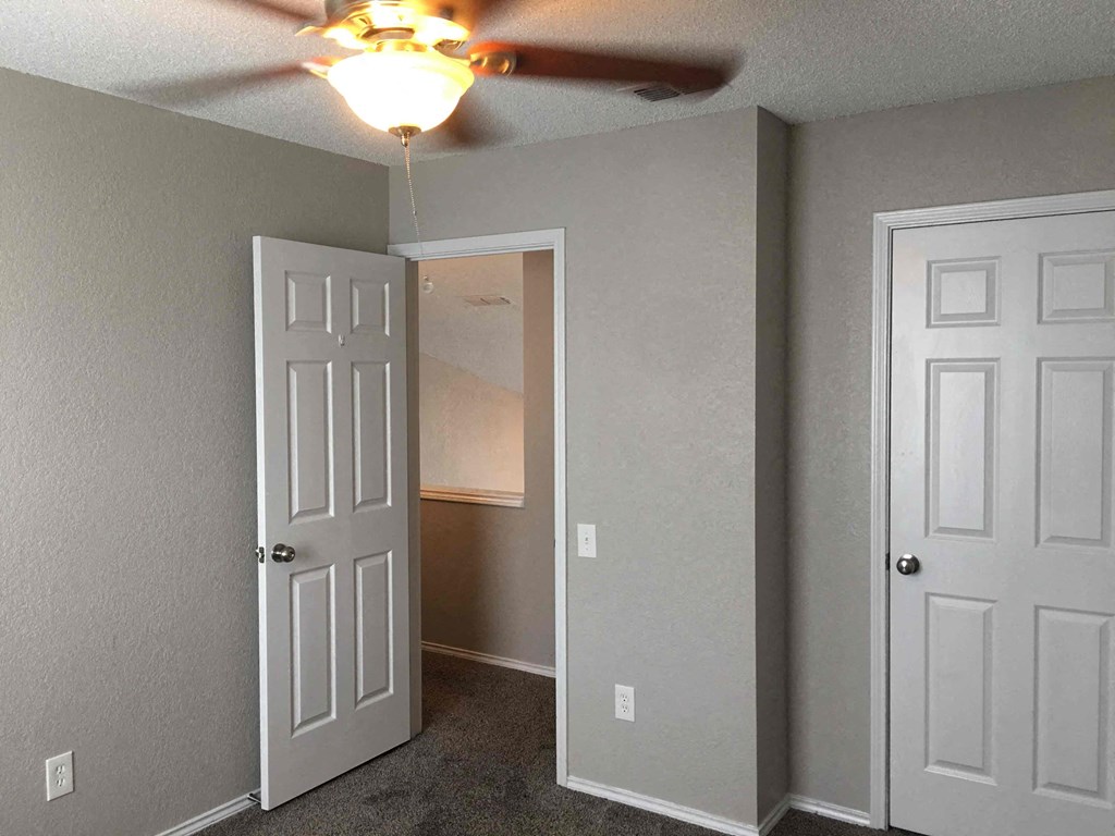 a bedroom with a ceiling fan and a closet
