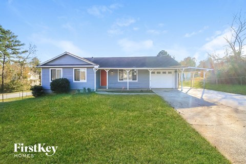 A blue house with a white garage door is for sale.