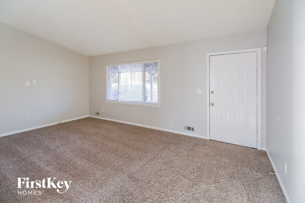 A room with a carpeted floor and a white door.