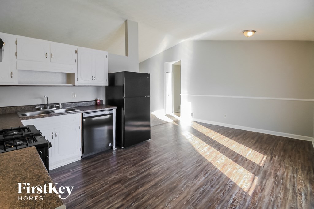 A kitchen with a stove top oven and a refrigerator.