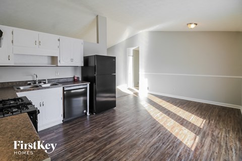A kitchen with a stove top oven and a refrigerator.