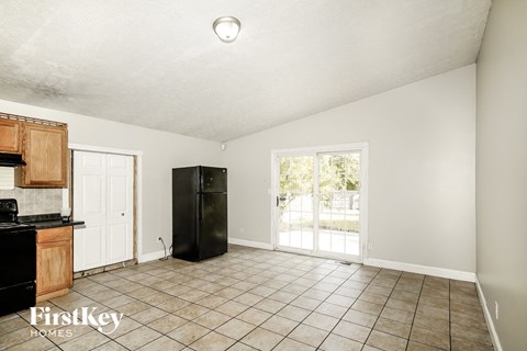 A kitchen with a black fridge and a black stove top oven.