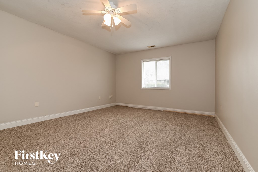 the master bedroom has carpeted floors and a ceiling fan