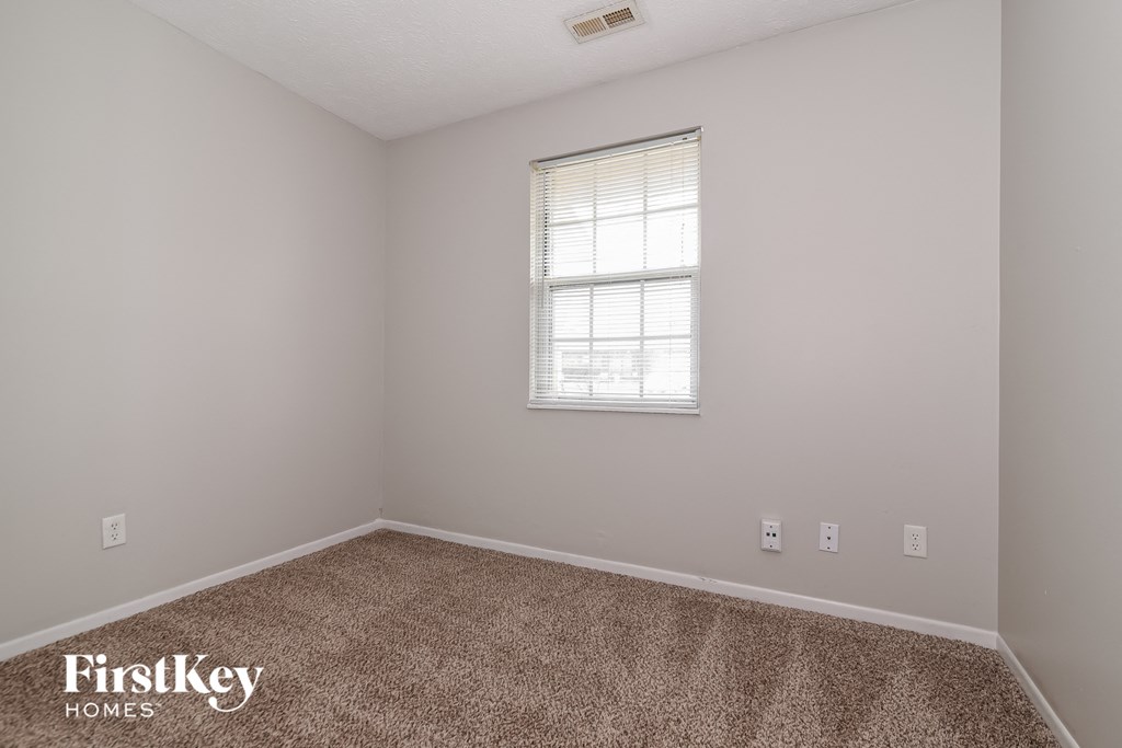 a bedroom with carpet and a window