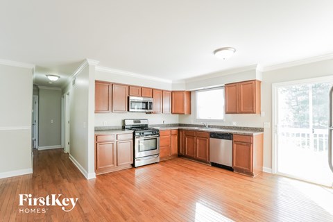 a kitchen with wood flooring and wooden cabinets