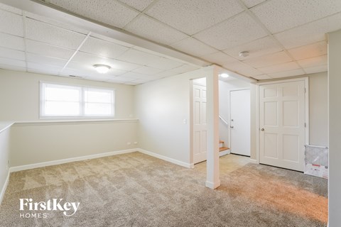 a bedroom with white walls and carpet and a door to a closet