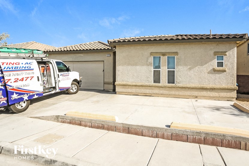 A white truck with a sign on it is parked in front of a house.