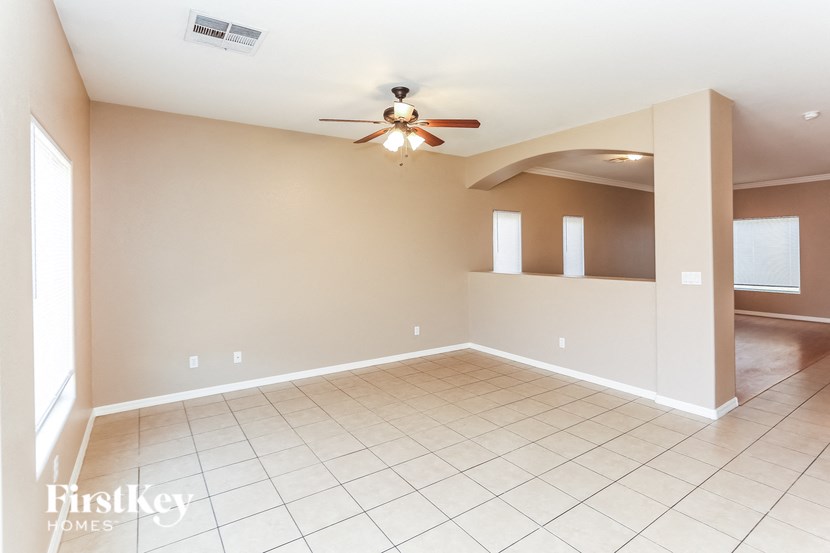 A spacious room with a ceiling fan and tiled flooring.