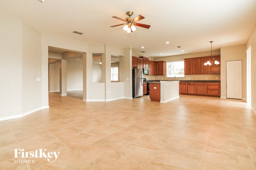 an empty kitchen and living room with a ceiling fan