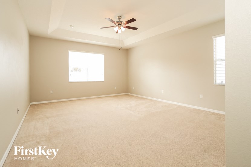 an empty living room with a ceiling fan