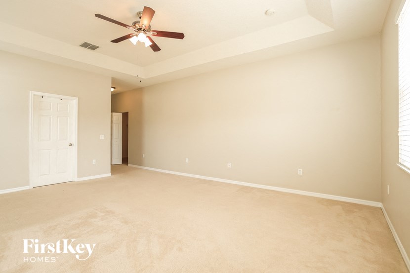 an empty living room with a ceiling fan