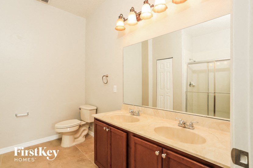 a bathroom with two sinks and a toilet and a large mirror