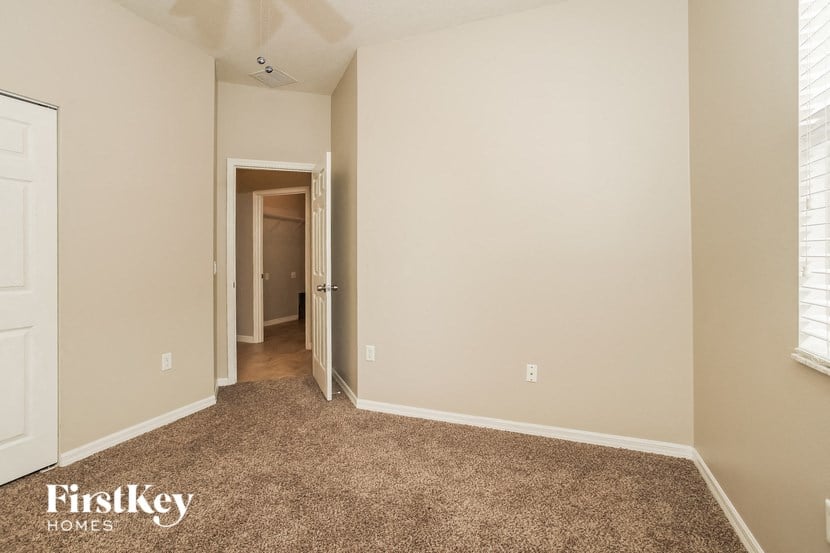 a bedroom with a carpeted floor and a door to a hallway