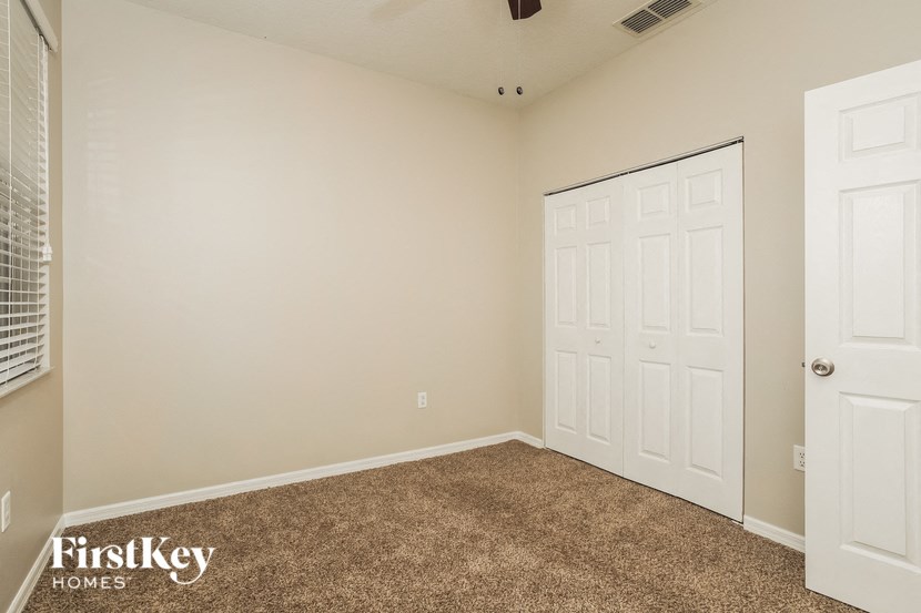 the bedroom of a home with a carpeted floor and a closet