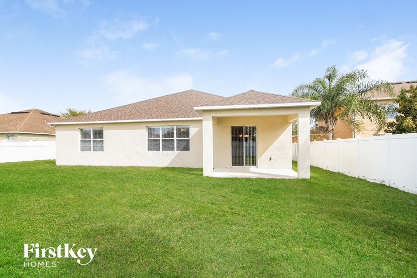 a white house with a lawn and a palm tree