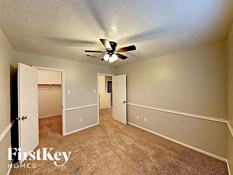 a bedroom with a ceiling fan and a closet