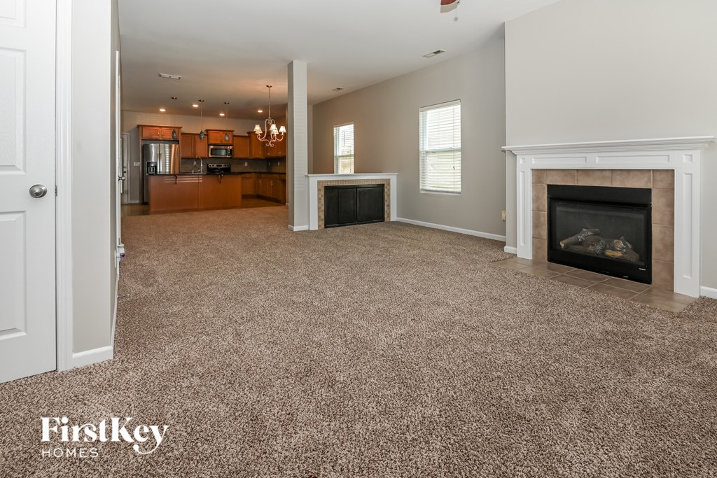 a living room with a fireplace and a carpeted floor