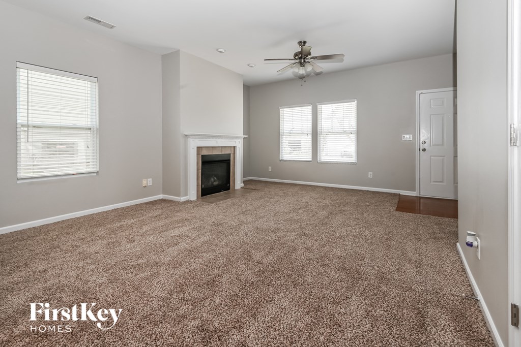 a living room with a carpeted floor and a fireplace