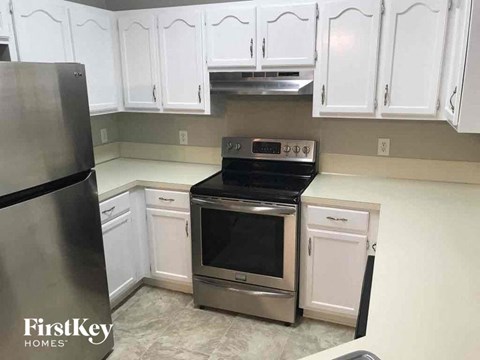 a kitchen with white cabinets and a stove and a refrigerator