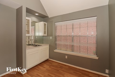 A kitchen with a sink and a window with blinds.