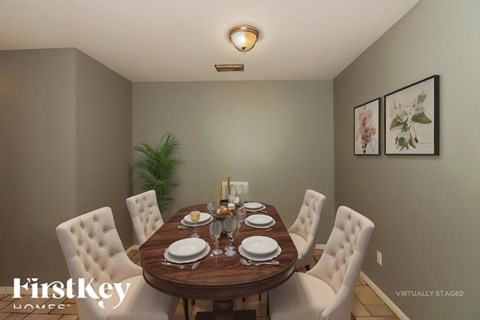 A dining room with a wooden table set for four.