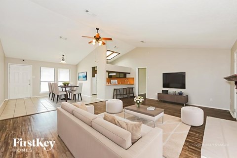 A spacious living room with a white couch and a television.