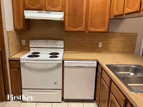 A kitchen with a white oven and a white dishwasher.