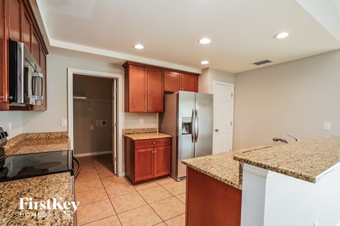 a kitchen with granite counter tops and stainless steel refrigerator