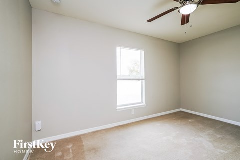 a bedroom with a ceiling fan and a window