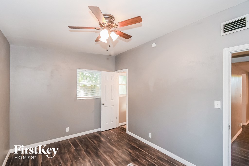 the living room of an empty house with a ceiling fan