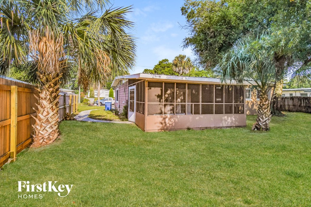 a backyard with palm trees and a tiny house