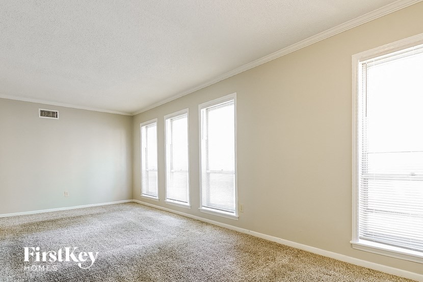 a empty living room with three windows