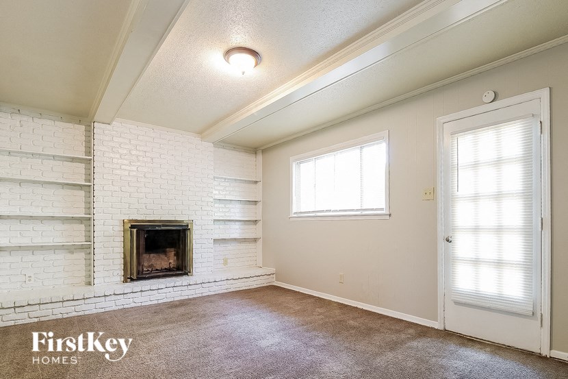 an empty living room with a fireplace and a door