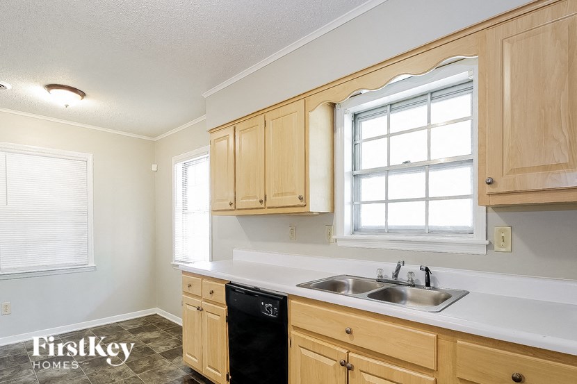 a kitchen with wooden cabinets and a sink and a window