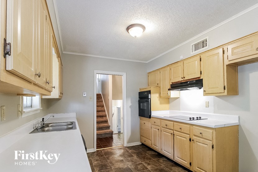 a kitchen with wooden cabinets and a white counter top