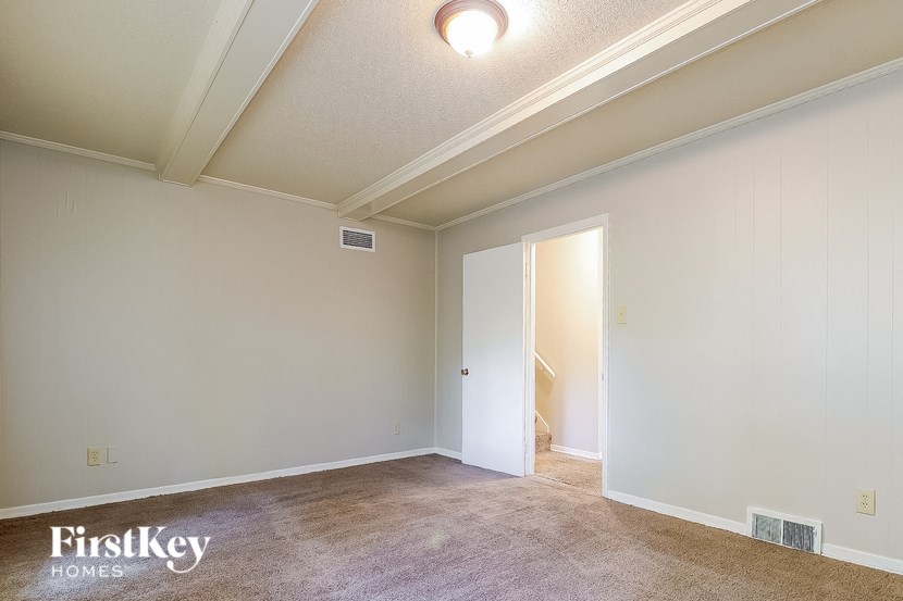 an empty living room with white walls and a door to a closet