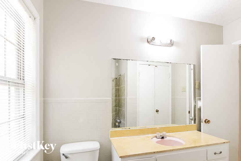 a bathroom with a sink toilet and a mirror