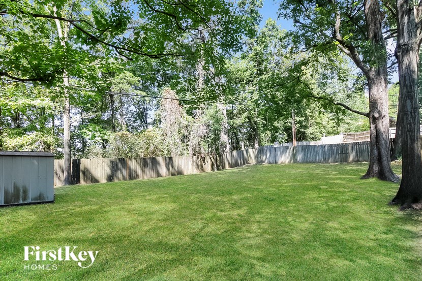 a backyard with trees and a fenced in area with grass