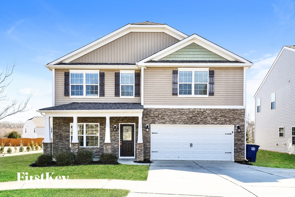 A two-story house with a garage and a driveway.