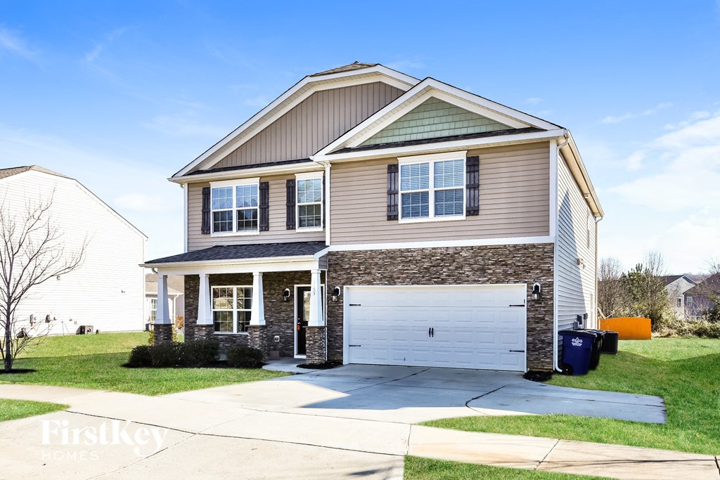 A two-story house with a garage and a driveway.