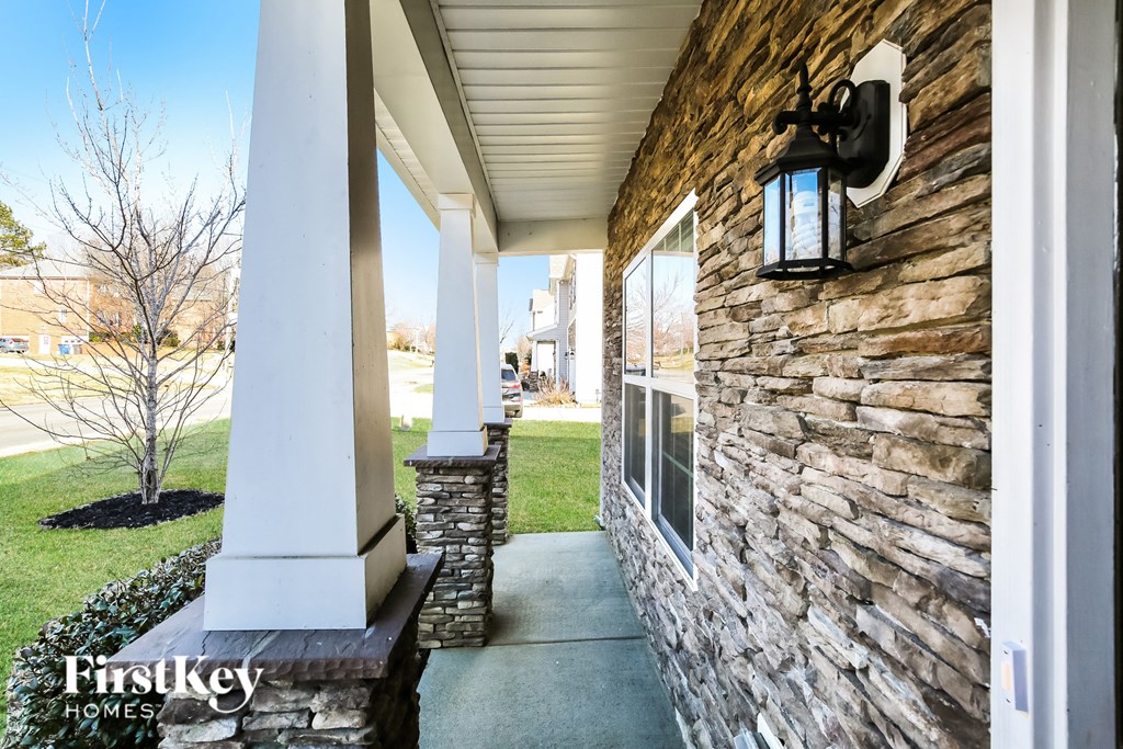 A porch with a lantern on the wall.