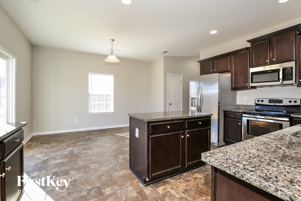 A kitchen with granite countertops and stainless steel appliances.