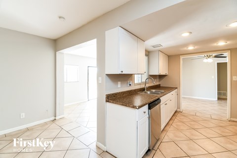 A kitchen with white cabinets and a brown countertop.