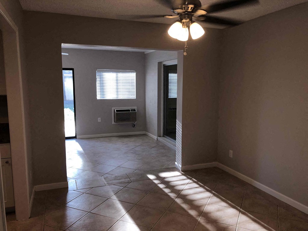 A room with a ceiling fan and tiled floor.