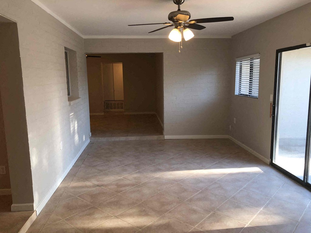 A room with a ceiling fan and tile flooring.